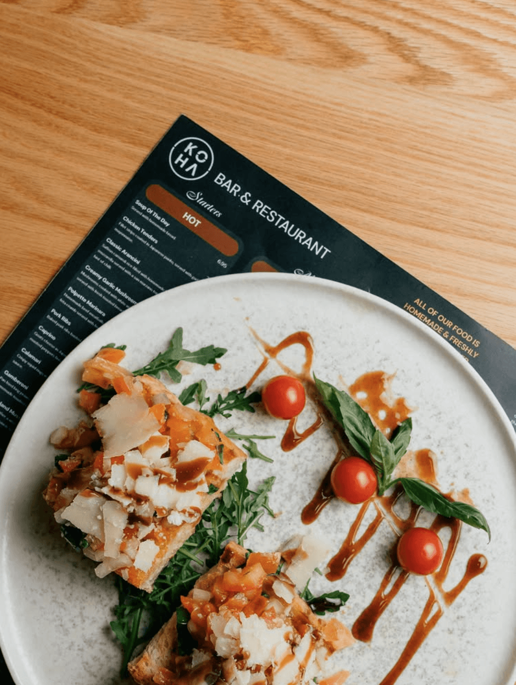 Bruschetta with tomatoes, parmesan, arugula and balsamic drizzle